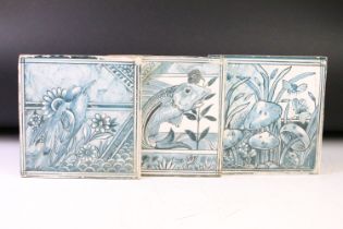 Three ceramic tiles with hand painted designs depicting mushrooms, a stylised fish, and a bird