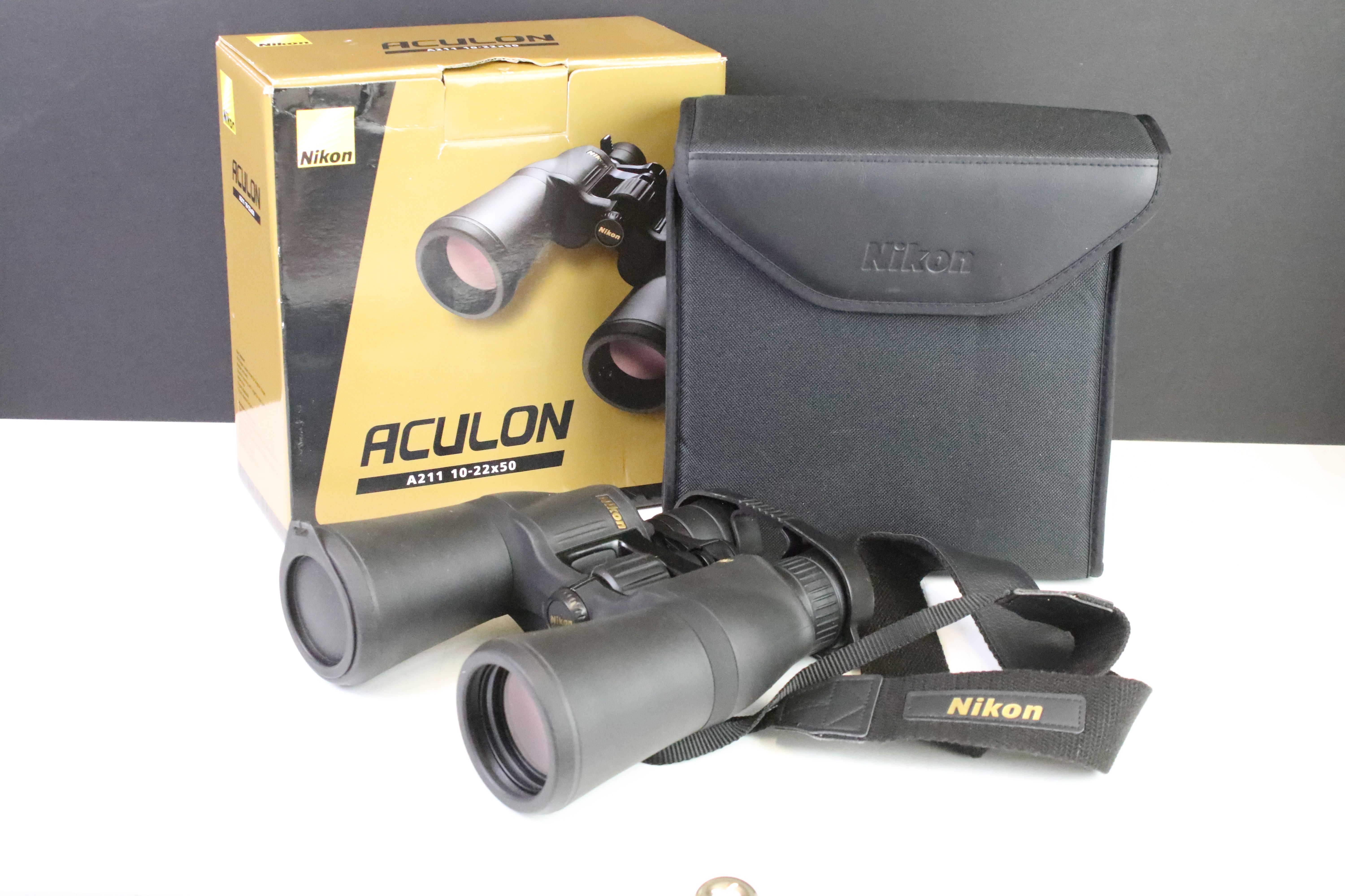 A set of Nikon Aculon A211 10-22x50 binoculars with original case and box.