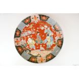 Large Japanese porcelain charger decorated in the Imari palette, decorated with figures, crane and a
