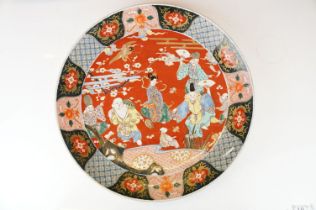 Large Japanese porcelain charger decorated in the Imari palette, decorated with figures, crane and a