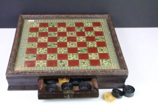 An antique glassed topped chequers board complete with boxwood chequers within drawer.