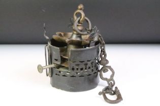 Two antique metal oil burners to include a hanging brass Indian example and a cylindrical pierced