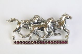 Silver horse brooch on ruby platform