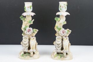 Pair of continental porcelain candlesticks with owl and floral encrusted decoration, blue anchor