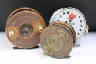 A collection of three vintage fly fishing reels to include two wooden examples with brass fittings.