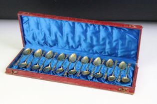 A cased set of eighteen teaspoons, lions head to finials, gilt white metal stamped .830.