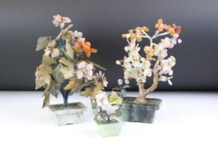 Three Chinese carved stone bonsai trees each with wire work trunks and coloured stone flowers and