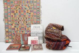 A large carpet bag together with a selection of books to include Indian tribal and amulets.