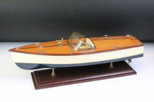 Painted wooden model of a speedboat, raised on a rectangular base, approx 48cm long