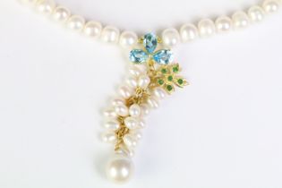 Freshwater pearl necklace with a blue topaz and emerald clasp