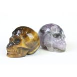 A collection of two carved and polished semi precious stones to include Tigers Eye and Amethyst