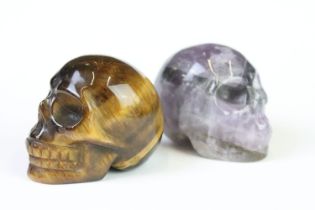 A collection of two carved and polished semi precious stones to include Tigers Eye and Amethyst