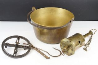 A vintage brass preserve pan together with a clockwork and a cast iron meat hanger.