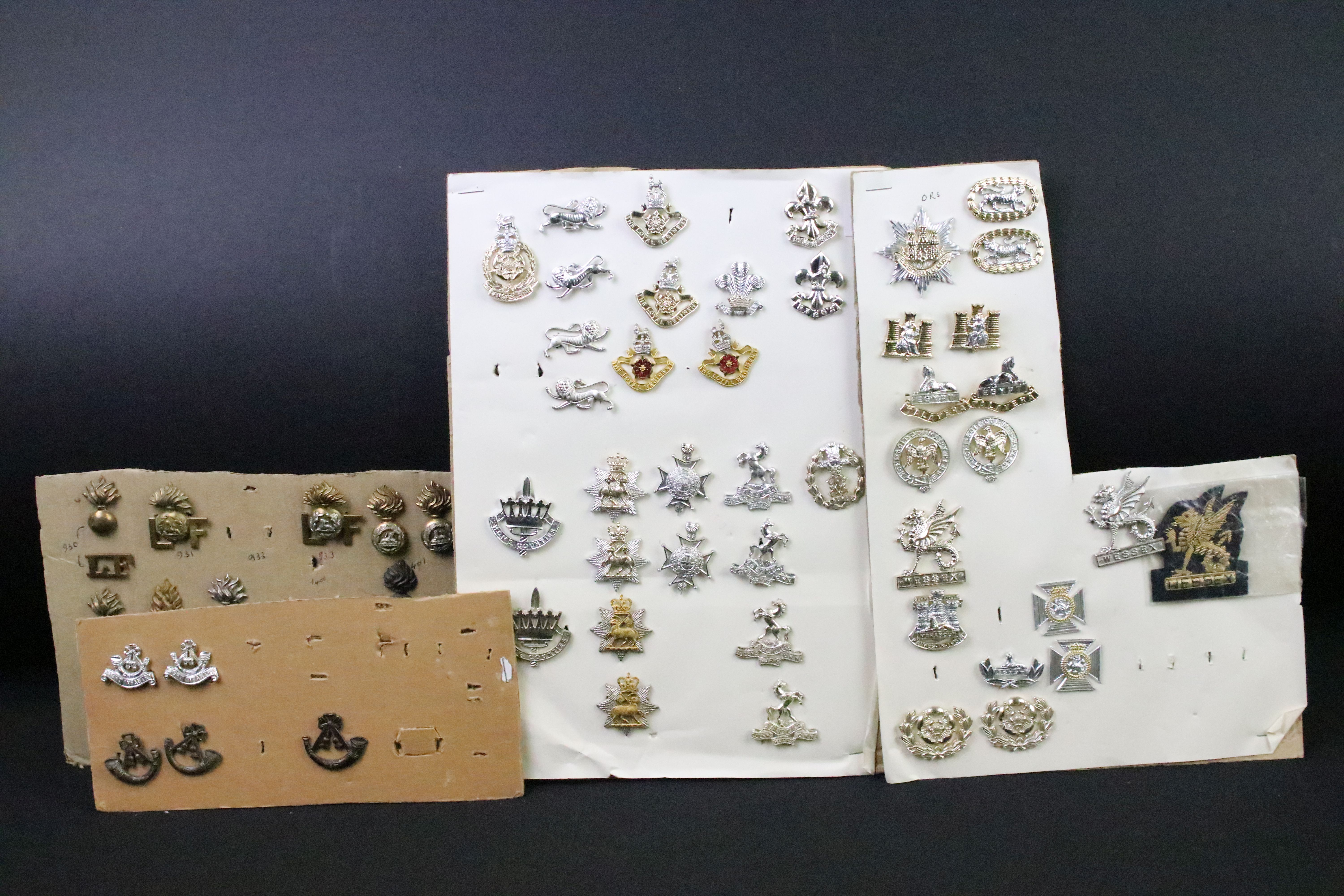 A collection of British military regimental cap and collar badges to include the Somerset Light