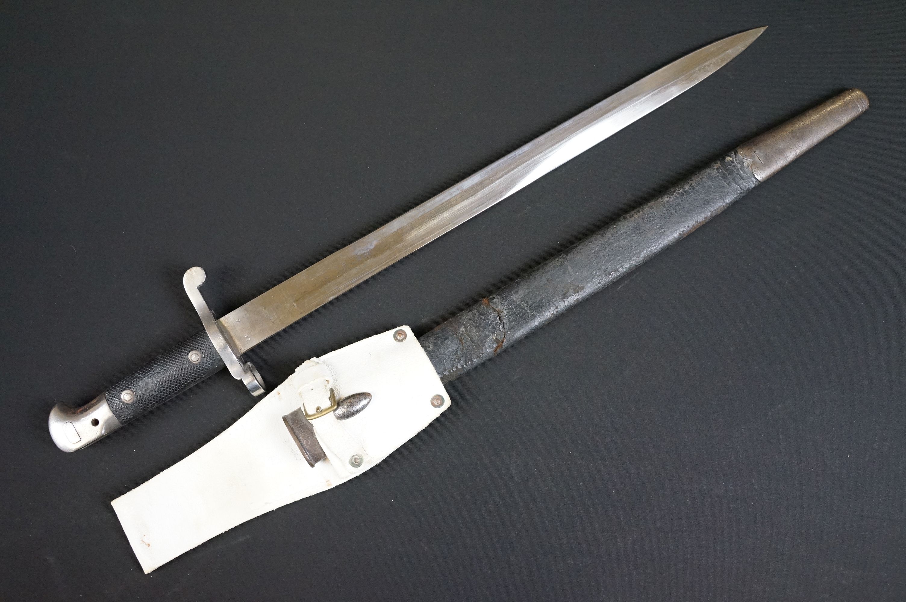 A British bayonet with good clear markings to the blade complete with scabbard and white leather