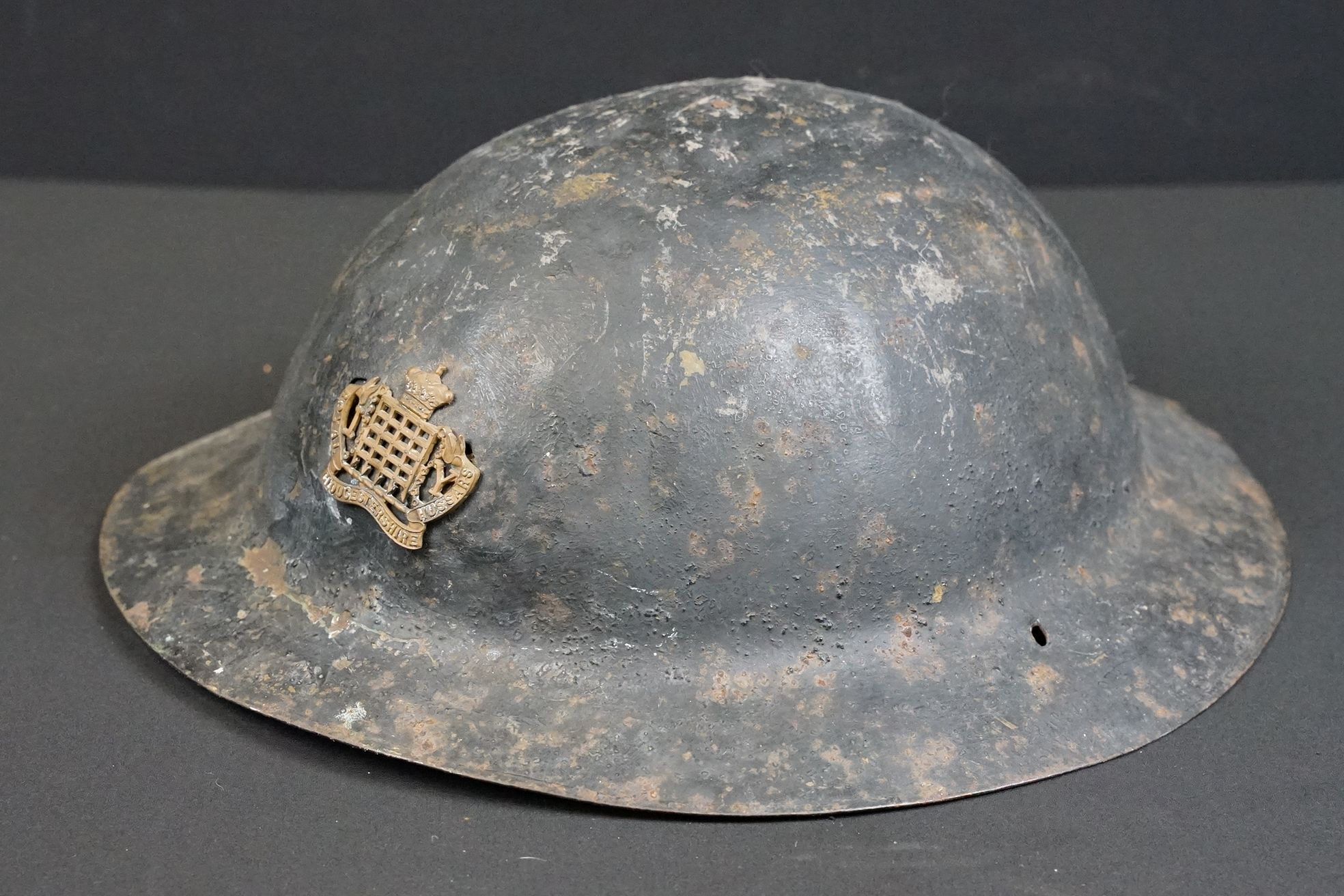 A British World War One Brodie helmet badged to the Royal Gloucestershire Fusiliers.