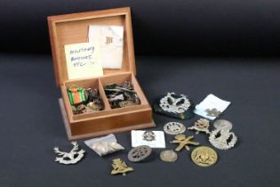 A collection of mainly British Military cap badges, collar badges, medal bars etc.. to include the