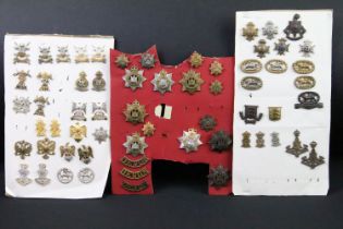 A collection of British military regimental cap and collar badges to include the Devonshire
