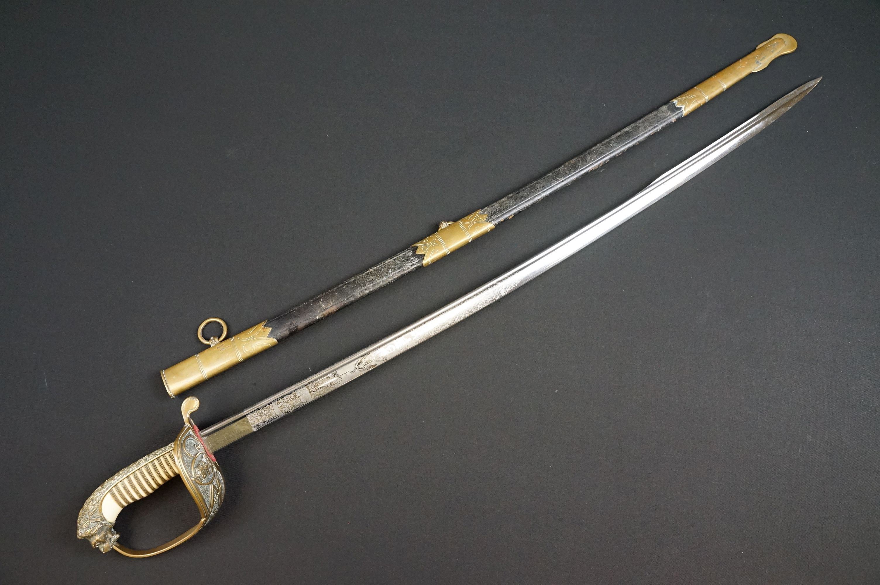 A German Imperial officers Navy dress sword complete with leather scabbard, the hilt is cast with