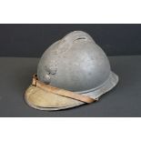 A World War One French Adrian Helmet complete with liner and veterans peak plaque.