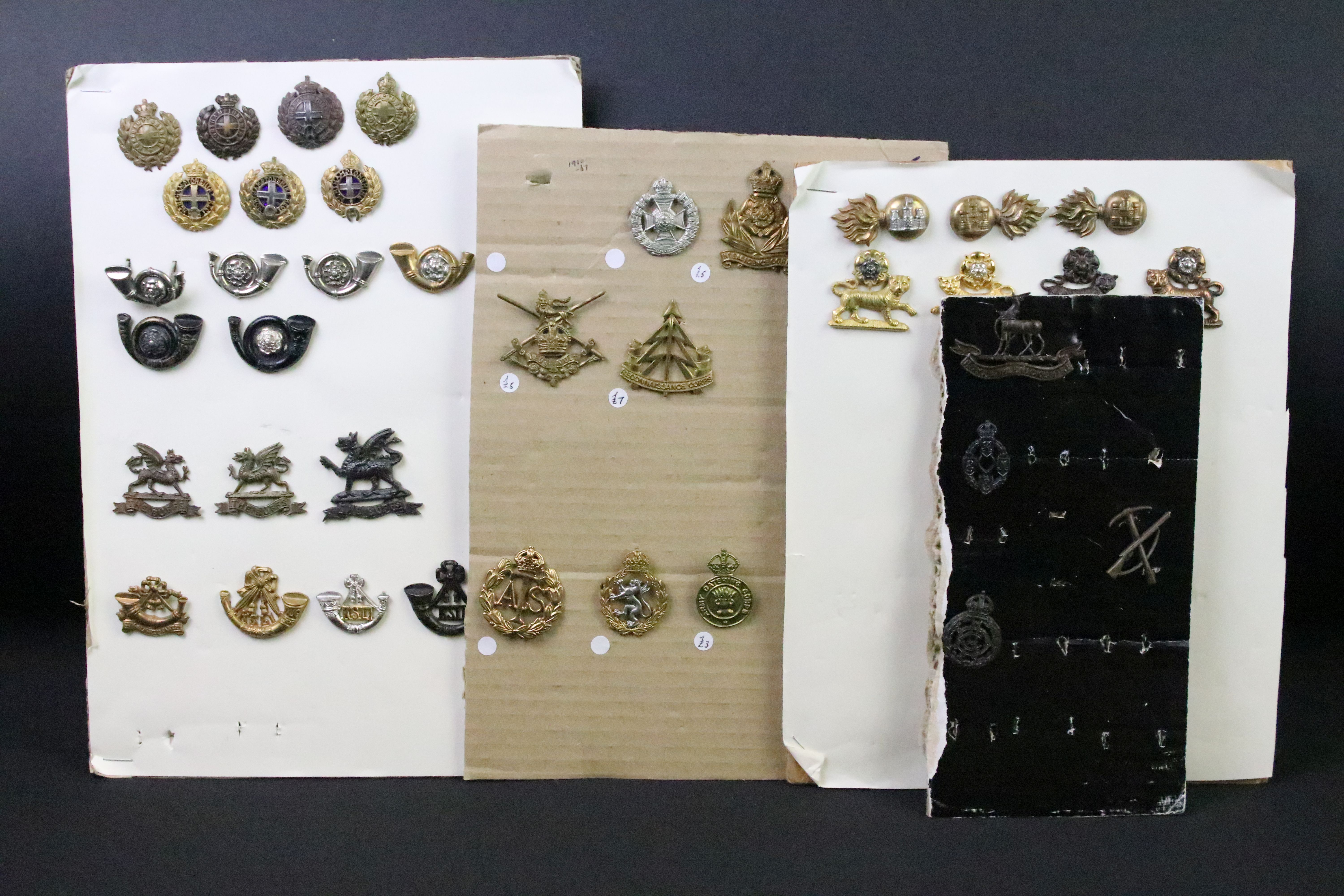 A collection of British military regimental cap and collar badges to include the King Somerset Light