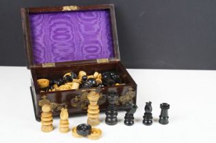 An early 20th century carved boxwood chess set with ornate wooden box.