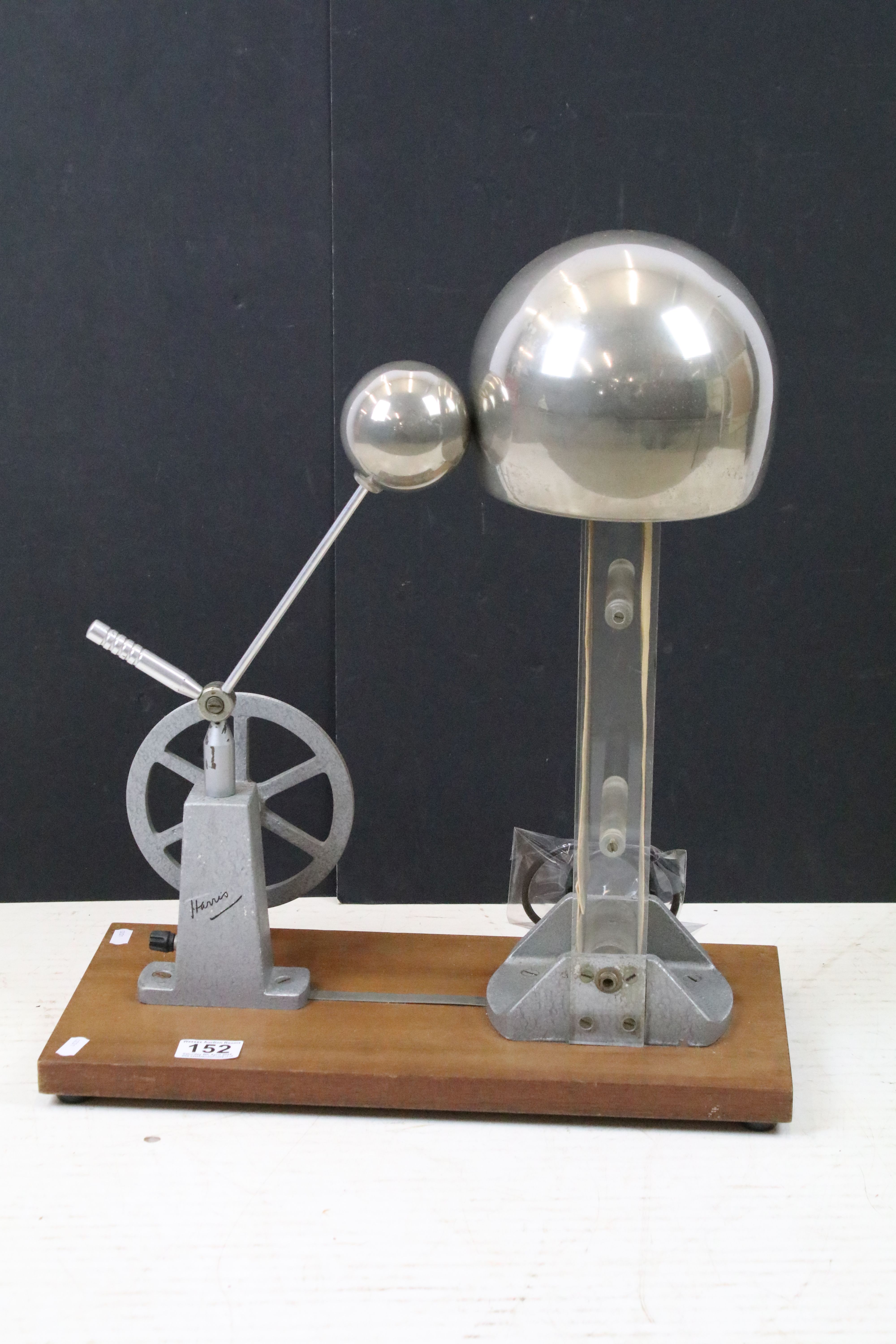 20th century Van de Graaf generator with crank handle, raised on a rectangular wooden base. Measures