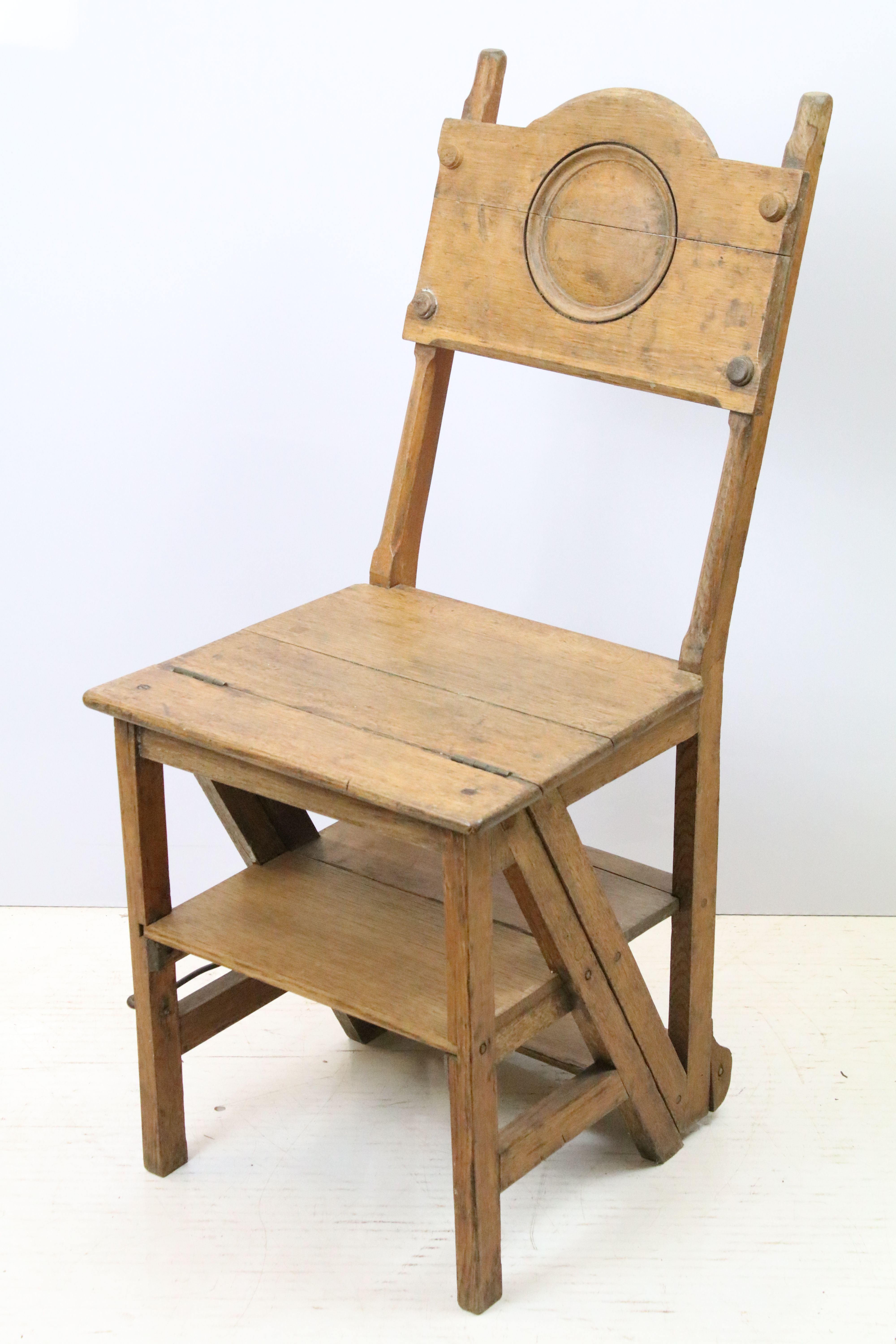 Arts and Crafts metamorphic library chair, the arched backrest with a central circular panel, on