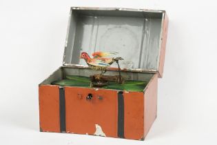 19th century tinplate chirping bird clockwork automaton, the bird perched amongst leaves, housed