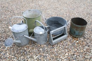 Two galvanised steel watering cans, a galvanised twin handled planter, a galvanised bucket with