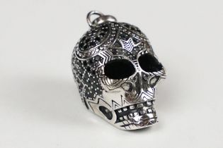 A 925 sterling silver tribal skull pendant set with black stones, marked 925 for sterling silver