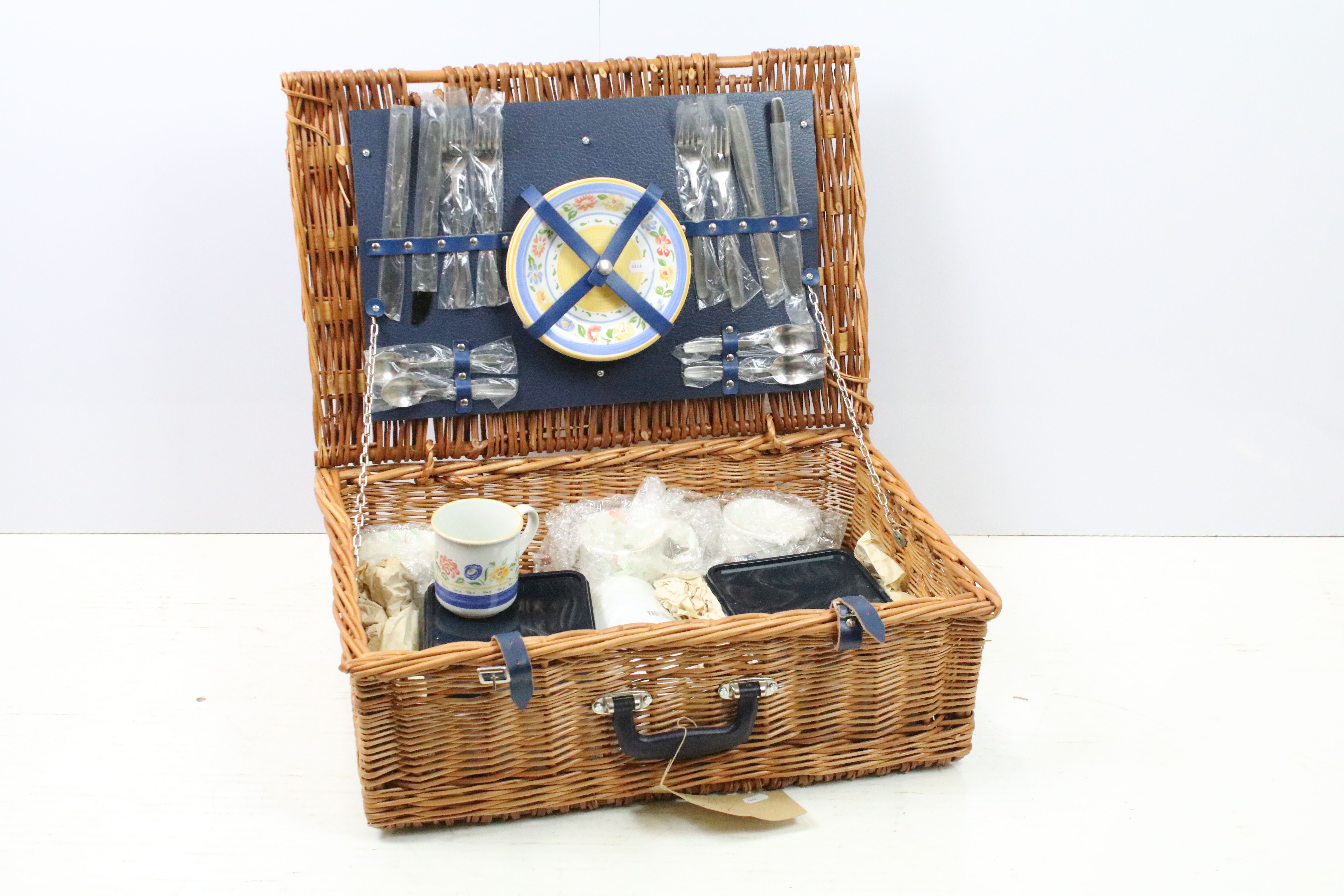 Wicker picnic hamper containing a four piece place setting