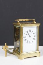 Brass cased carriage clock with bevelled glass panels, the white dial with black Roman numerals