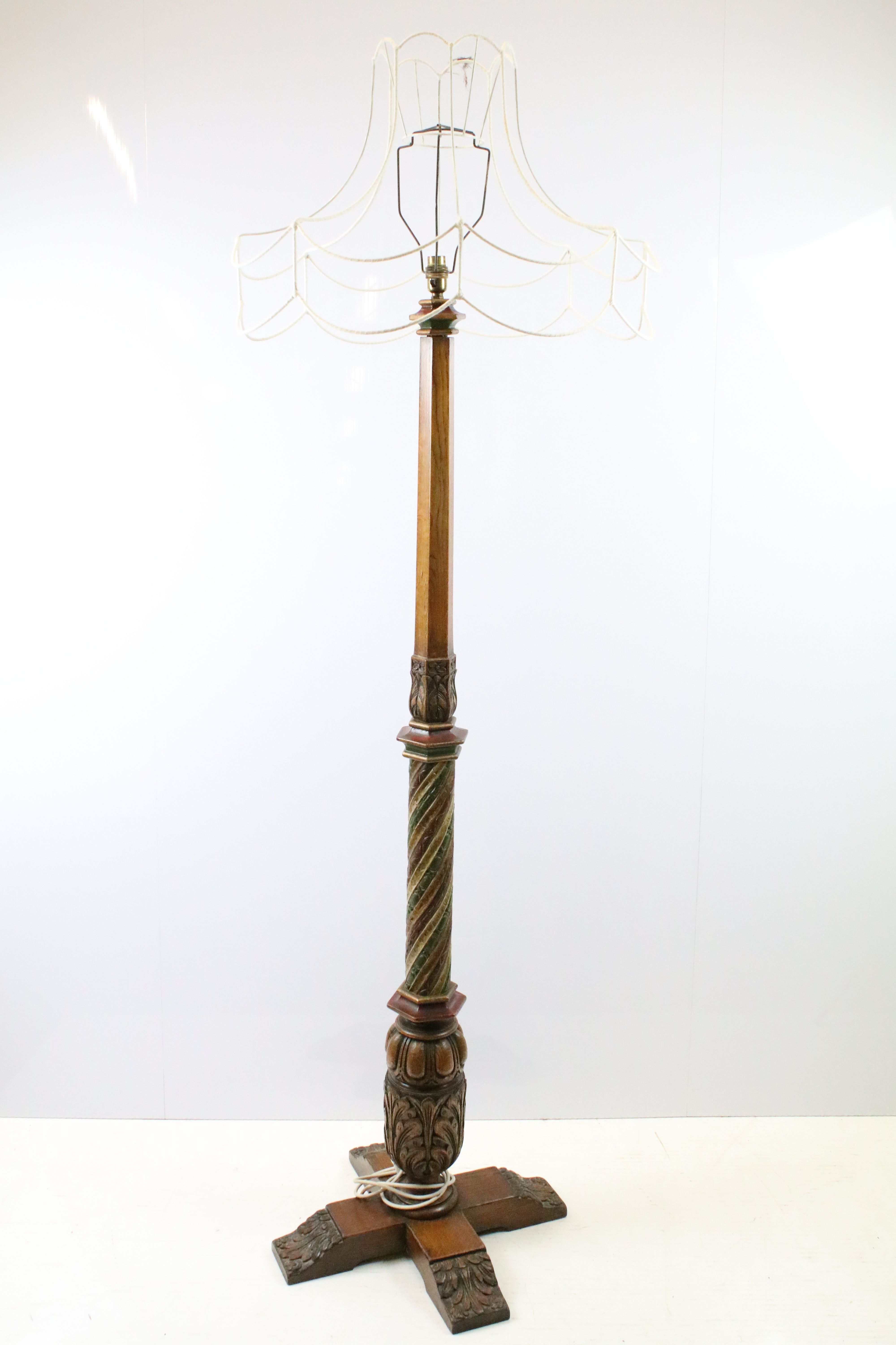 20th century substantial carved oak standard lamp, the four feet carved with flowers and leaves, the