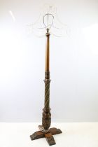 20th century substantial carved oak standard lamp, the four feet carved with flowers and leaves, the