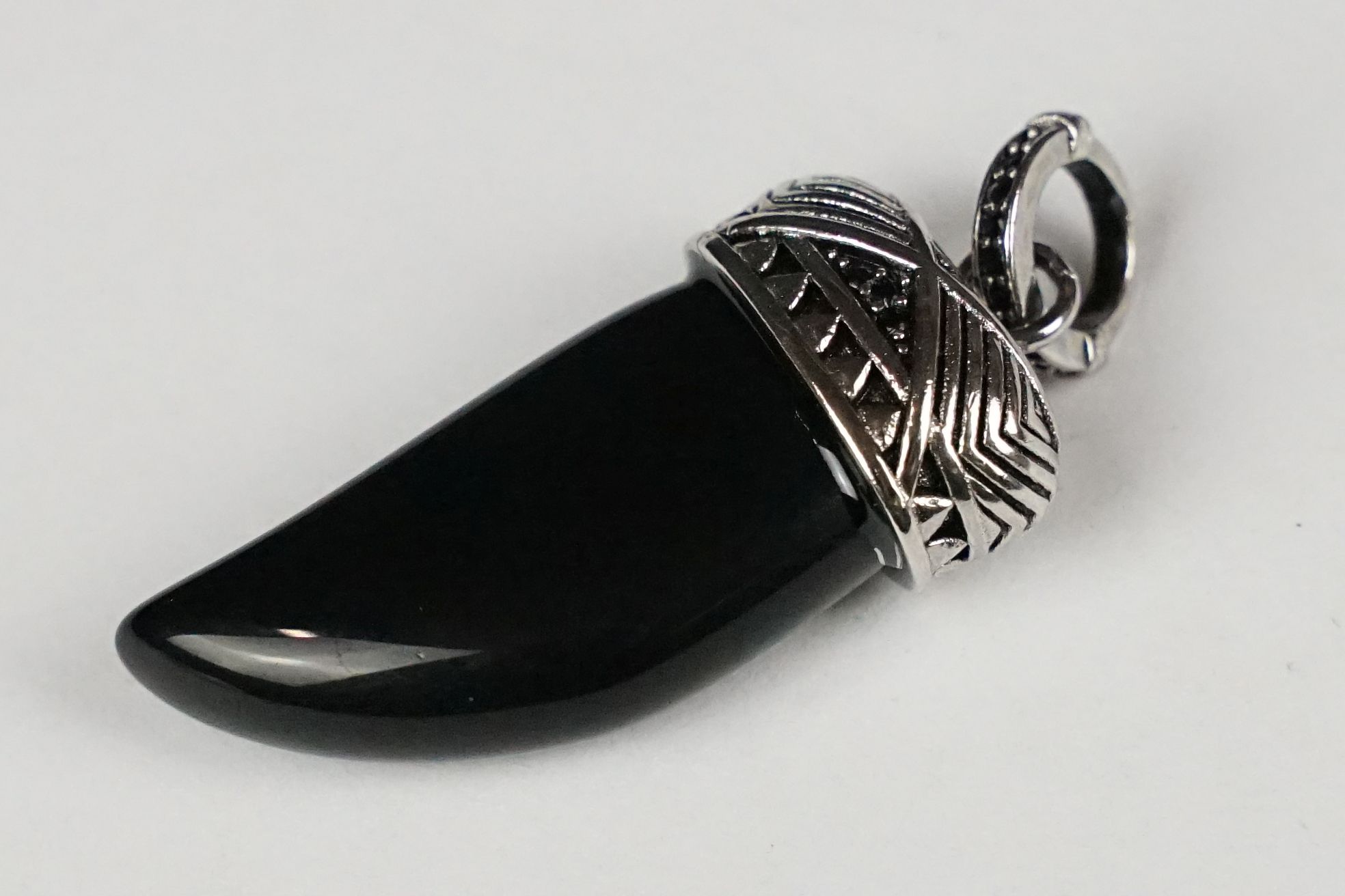 A 925 sterling silver and black onyx pendant in the form of a tigers tooth.