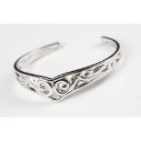 A 925 sterling silver open ended bangle with pierced Celtic style decoration, marked 925 for