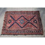 Middle Eastern red ground rug, with central medallion and two half medallions, 197cm x 132cm