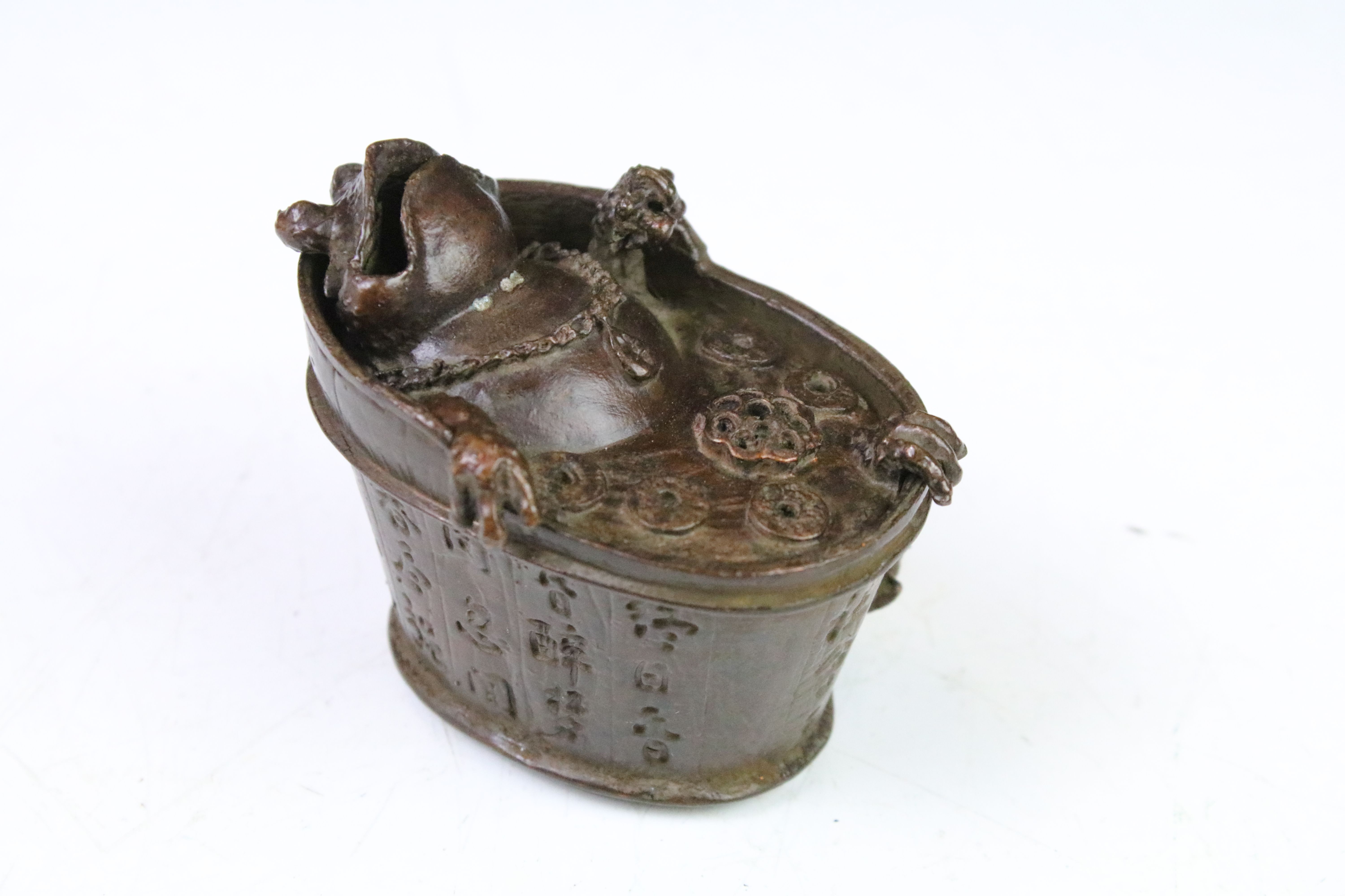 Chinese copper incense burner in the form of a toad bathing in a bathtub, with character marks.