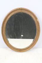 Bevelled glass mirror of oval form with oval painted plaster frame