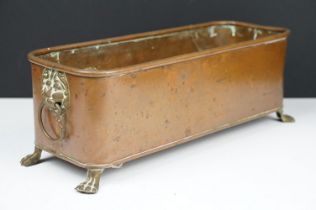 Copper planter of rectangular form with rounded corners and rolled edge, having a pair of lion