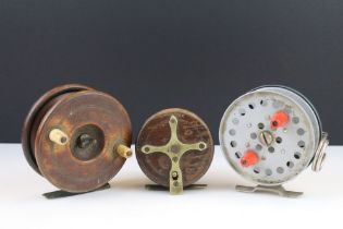 A collection of three vintage fly fishing reels to include two wooden examples with brass fittings.