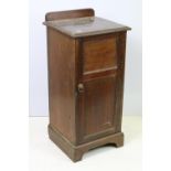 Early 20th Century mahogany side cabinet having a flared top with panelled cupboard with shelf