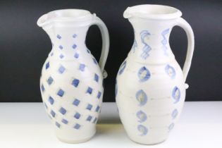 Two pottery jugs with underglaze blue repeating decoration and single handles, tallestapprox 36cm