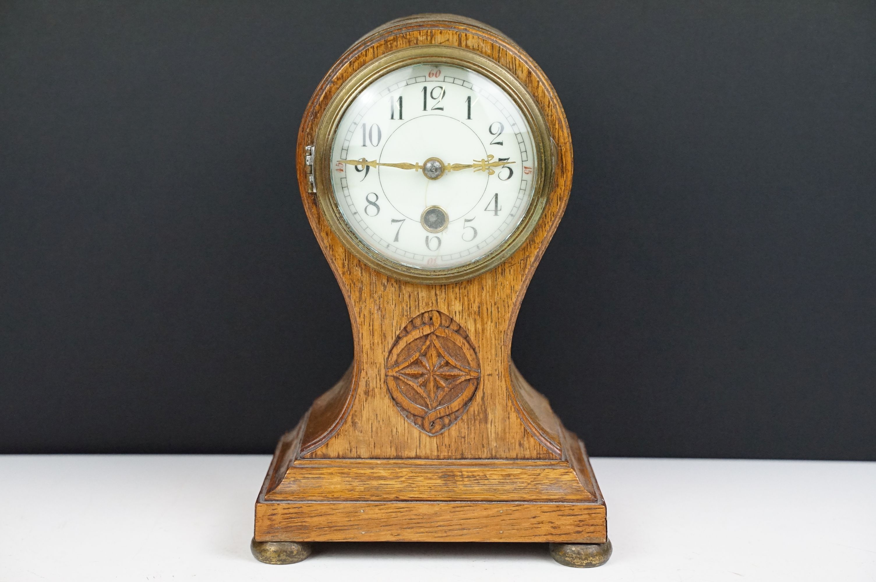 Edwardian balloon oak mantel clock with white enamel dial and carved detail, approx 22.5cm high