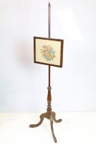 Victorian mahogany fire screen stand having an embroidered framed picture raised on tripod stand.