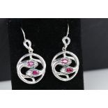 Pair of silver and ruby snake style earrings, cased