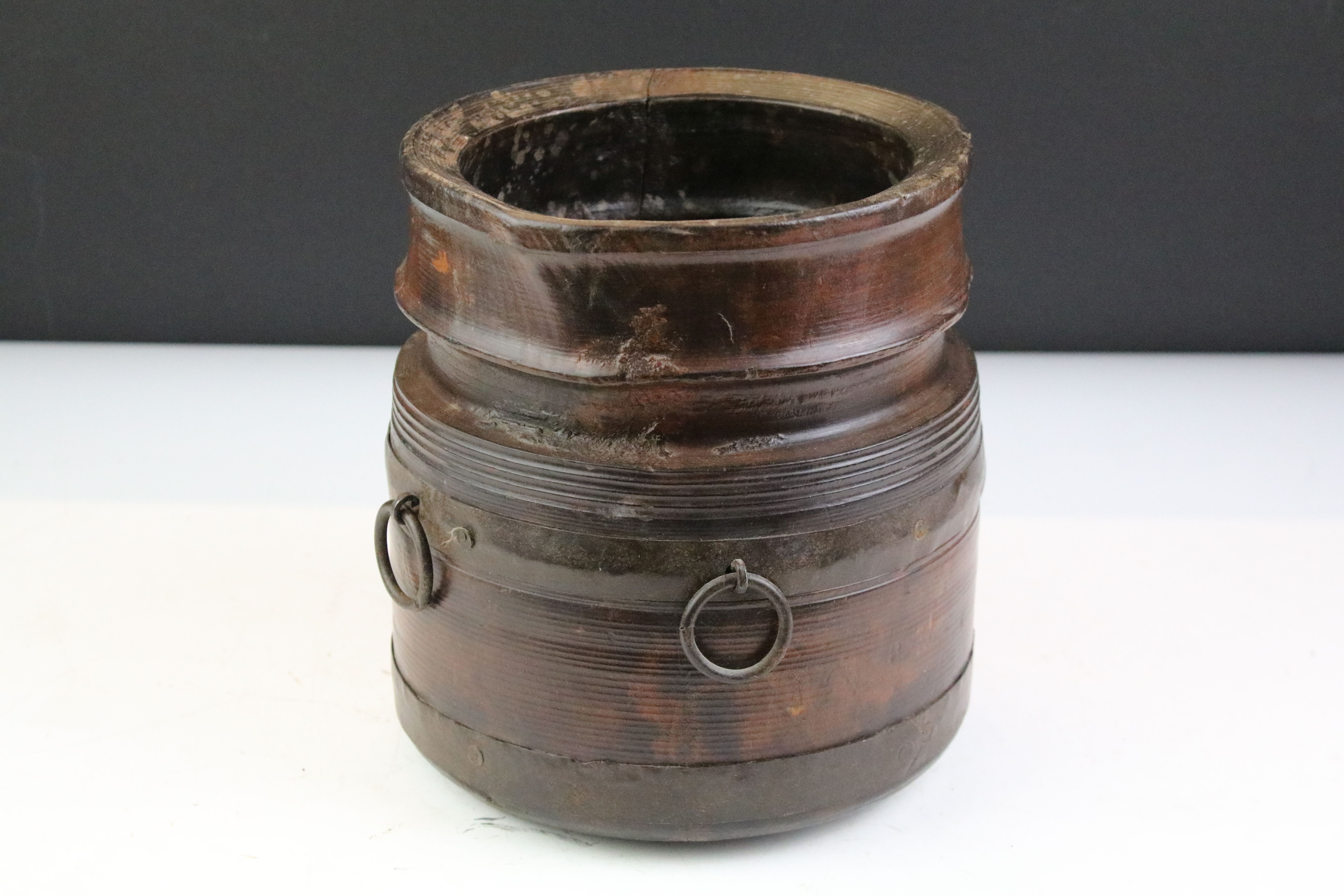 19th Century turned wooden pot having three cast metal ring handles. Measures 19cm tall.