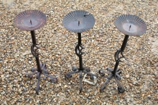 Set of three wrought iron floor standing candlesticks with spiralling to support, approx 62cm high