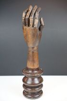 Artist model hand with articulated fingers, raised on a turned wooden base, approx 44cm high